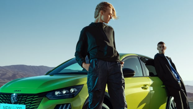 Woman next to new PEUGEOT 208